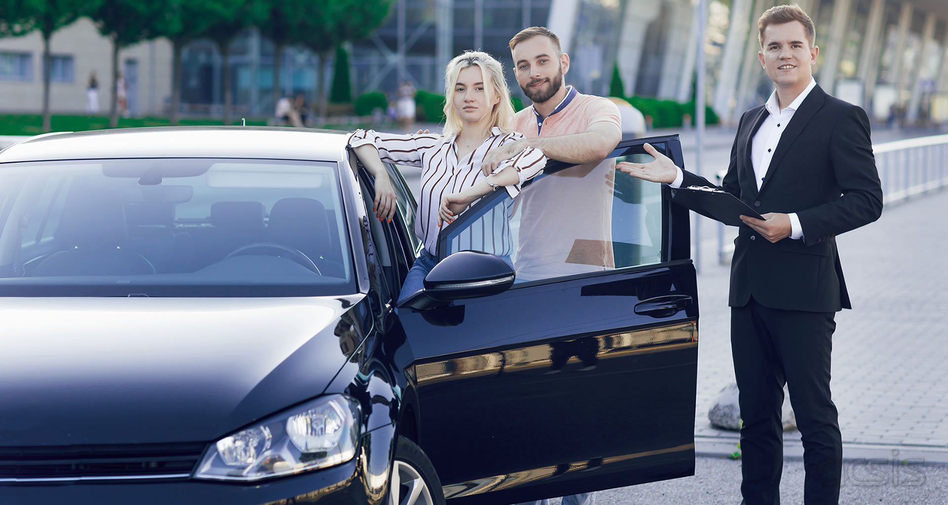 Automotive dealership team beside a vehicle